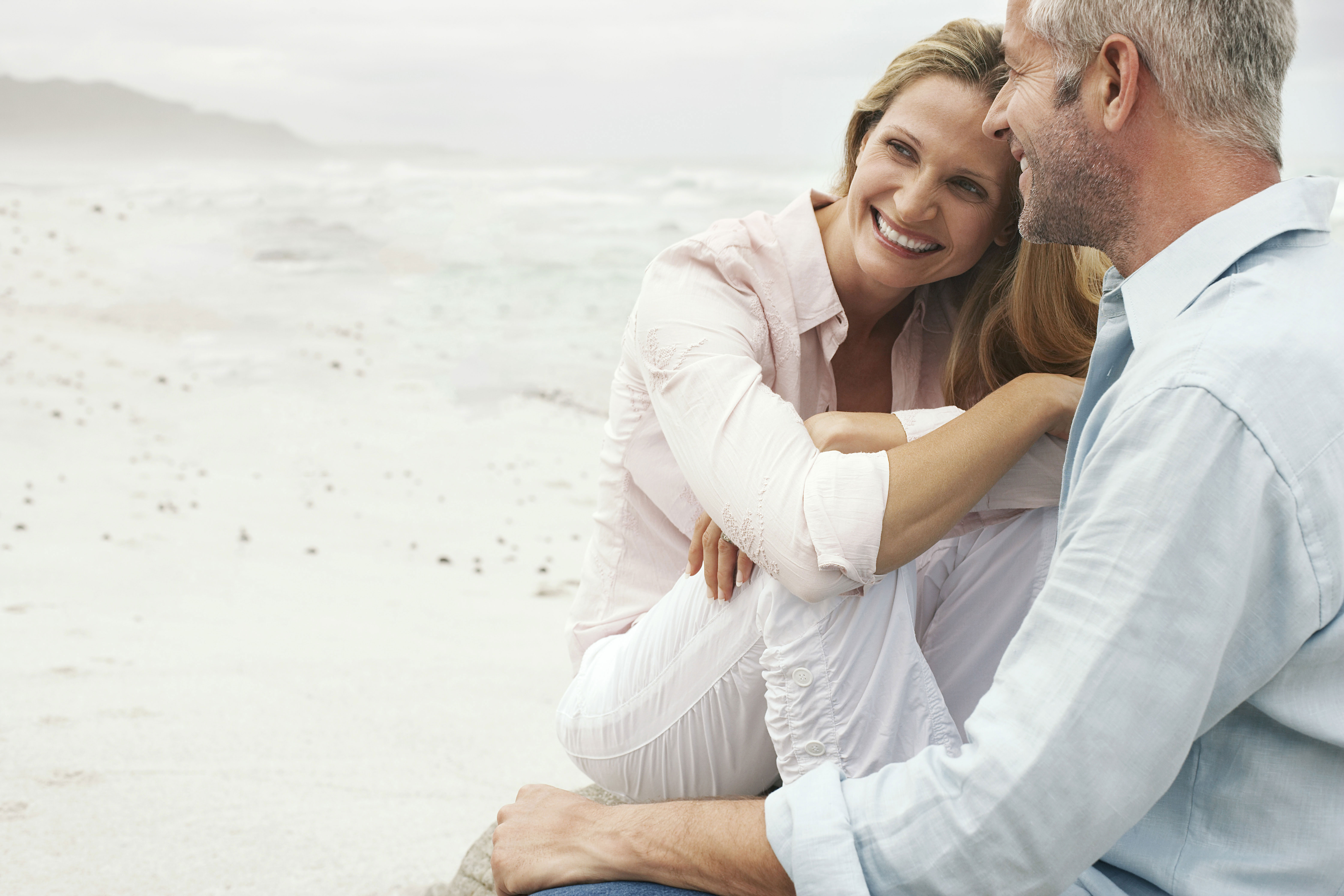 Mature couple sitting on beach sexual health